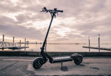 Apollo Ghost electric scooter - full scooter, angled view, handlebars on left, bright cloudy sky