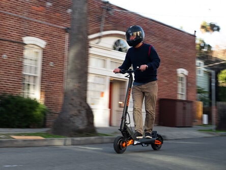 Inokim OXO Electric Scooter - man riding to camera, side flank view, full view