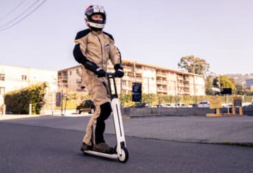 Man in full safety gear riding an electric scooter