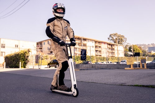 Man in full safety gear riding an electric scooter